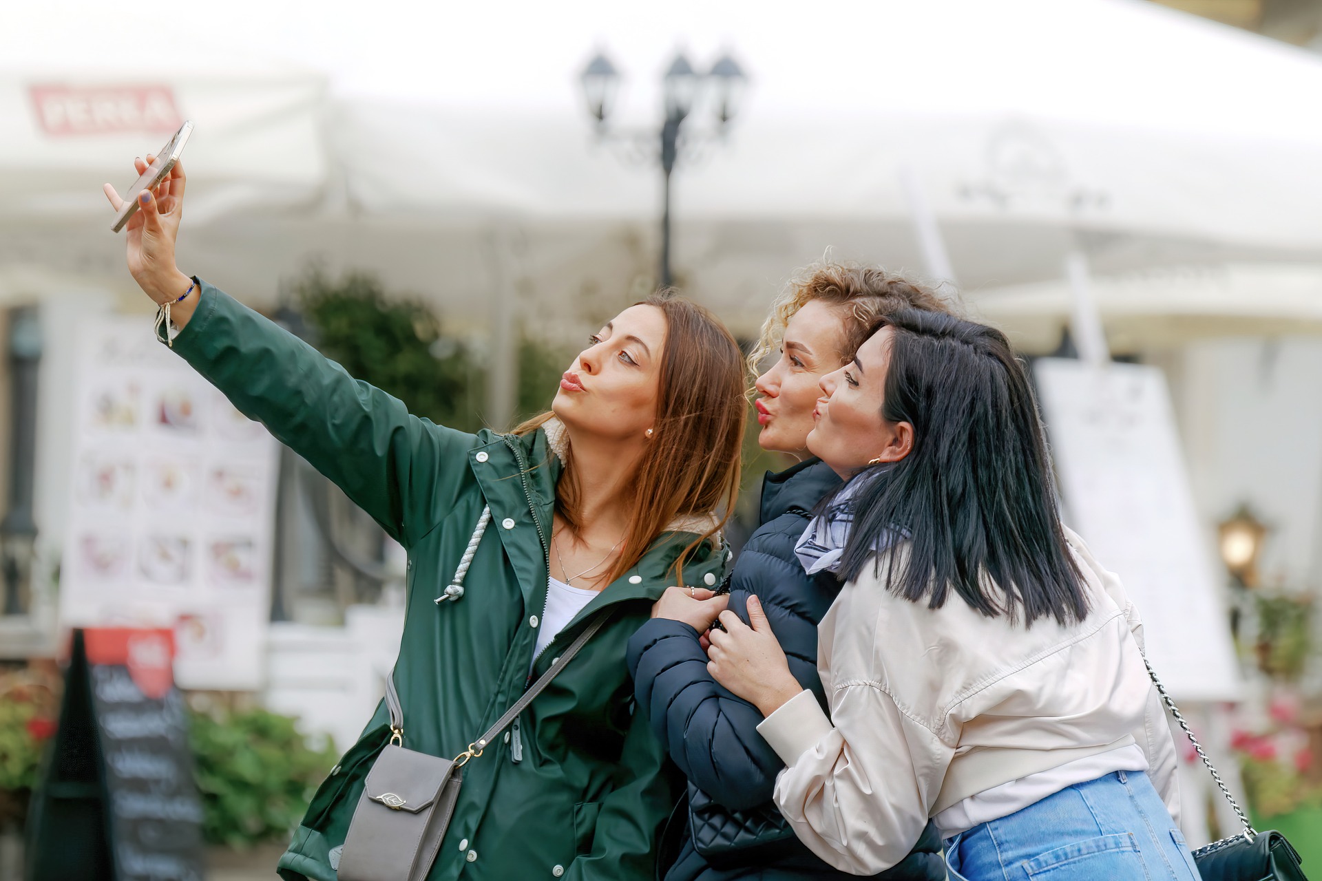 Photo of three Young women taking selfies